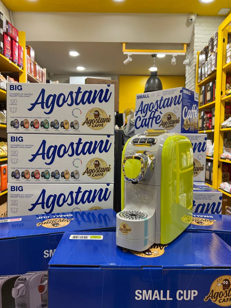 Una macchinetta per capsule davanti alle confezioni di caffè